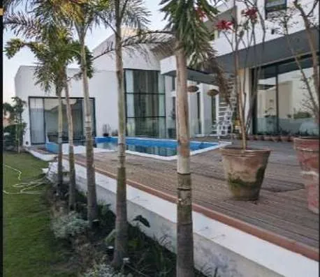 Modern villa with pool, timber deck and palm trees in DHA Phase 5, Lahore